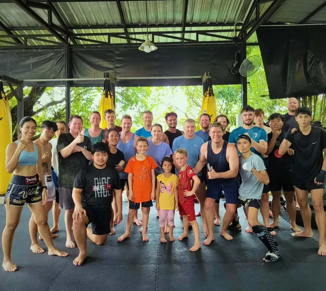 The Wildcat team: coaches and fighters lined up in the open-air gym, Chiang Mai
